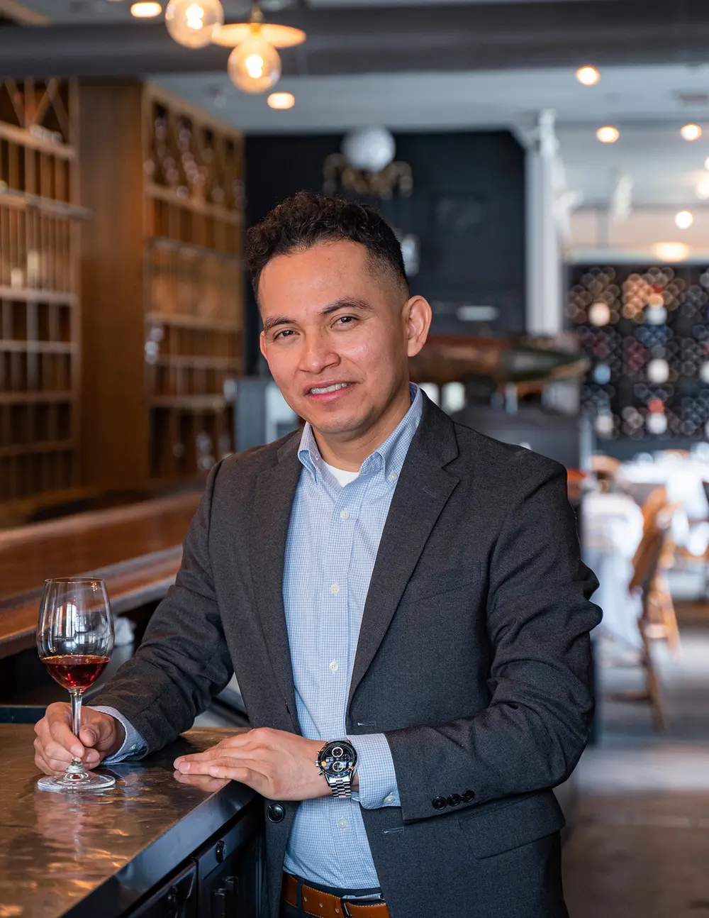 Donaciano Donny Betancourt holding a glass of wine in a restaurant